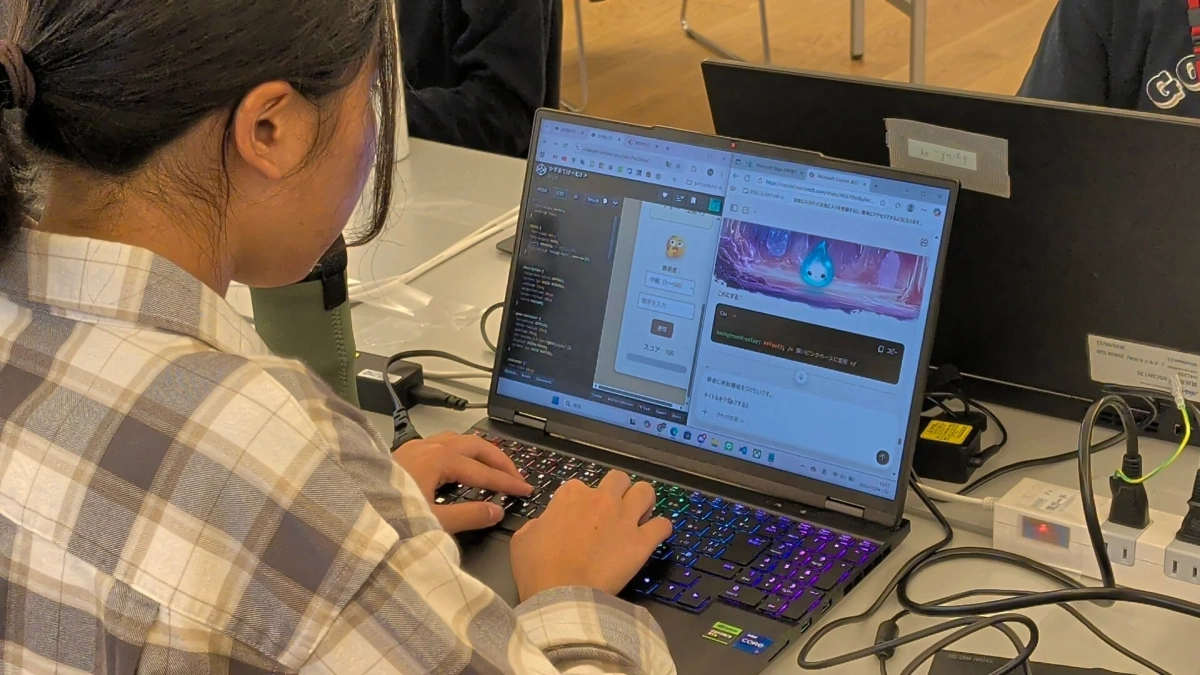 ラップトップでプログラミングコードとウェブページを表示し作業する人物