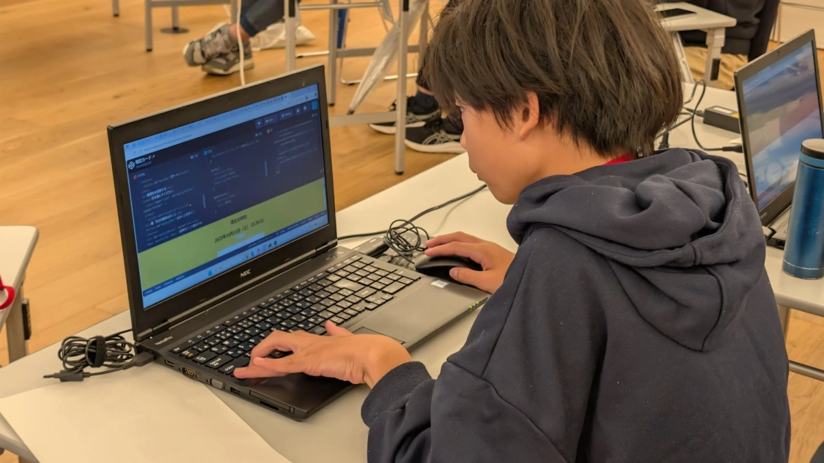 ノートパソコンに向かいプログラミング学習や作業をする若者