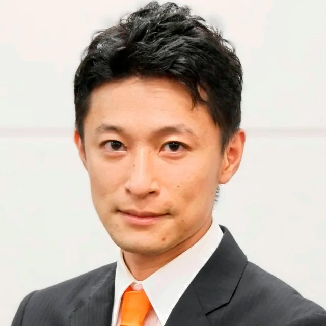 ビジネススーツとオレンジ色のネクタイを着用したアジア系の男性の顔のアップ