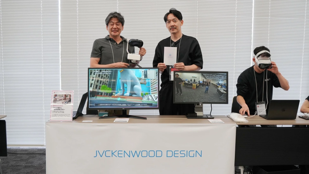 JVCKENWOOD DESIGNのブースで、男性たちがVRヘッドセットやディスプレイを囲んで未来の購買体験を紹介