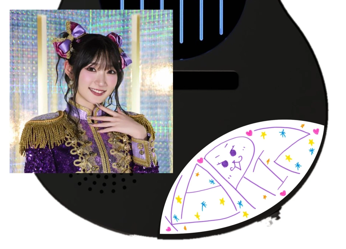 紫と金色の華やかなステージ衣装を着た女性アイドルが笑顔でポーズをとっています